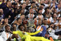 Jogadores do Corinthians, uniformizados de preto e branco, erguem o troféu da Copa do Brasil em meio à celebração no gramado do Maracanã, comemorando a conquista do tetracampeonato após a vitória contra o Vasco.