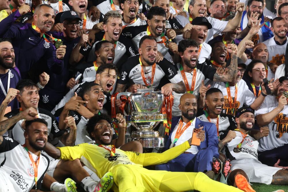 Corinthians vence Vasco e conquista o tetracampeonato da Copa do Brasil 5 Jogadores do Corinthians, uniformizados de preto e branco, erguem o troféu da Copa do Brasil em meio à celebração no gramado do Maracanã, comemorando a conquista do tetracampeonato após a vitória contra o Vasco.