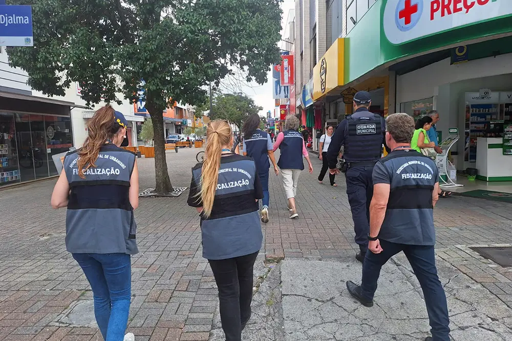 São José dos Pinhais fiscaliza comércios em força-tarefa na Rua XV de Novembro 2 Agentes da prefeitura e guardas municipais de São José dos Pinhais verificam documentação de lojas no centro da cidade