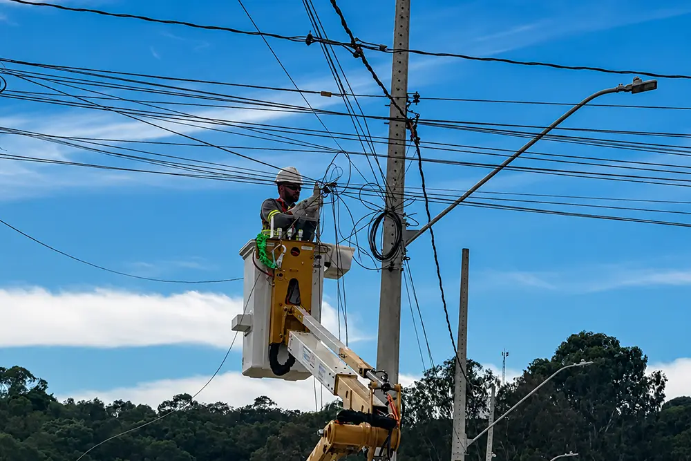 Equipes técnicas da Copel e de empresas de telefonia removem fiação morta e organizam cabos de internet