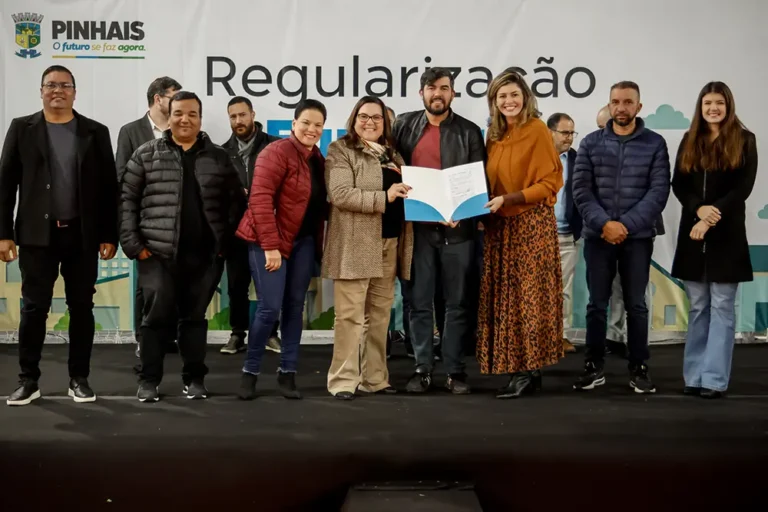 A prefeita Rosa Maria, acompanhada do vice-prefeito, Marcinho, da deputada Marli Paulino, da secretária Ana Paula, e diversas outras autoridades, entrega matrículas que garantem segurança jurídica e plena integração dos loteamentos ao planejamento urbano