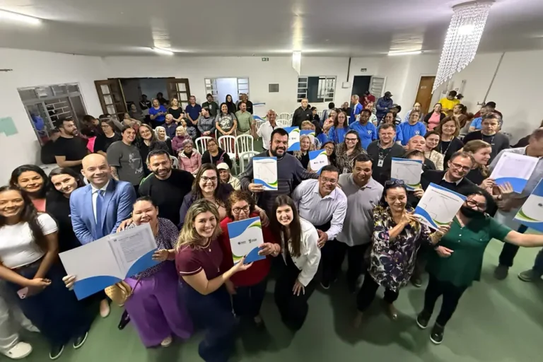 Moradores da Vila União II exibem os documentos de propriedade recebidos gratuitamente durante solenidade oficial que contou com a presença da prefeita Rosa Maria, vereadores e demais autoridades
