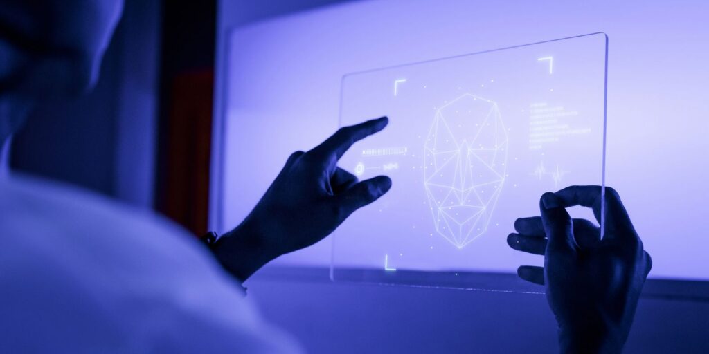 designer usando uma tecnologia futurista de tela de tablet digital transparente Deepfakes: Proibição e desafios nas eleições